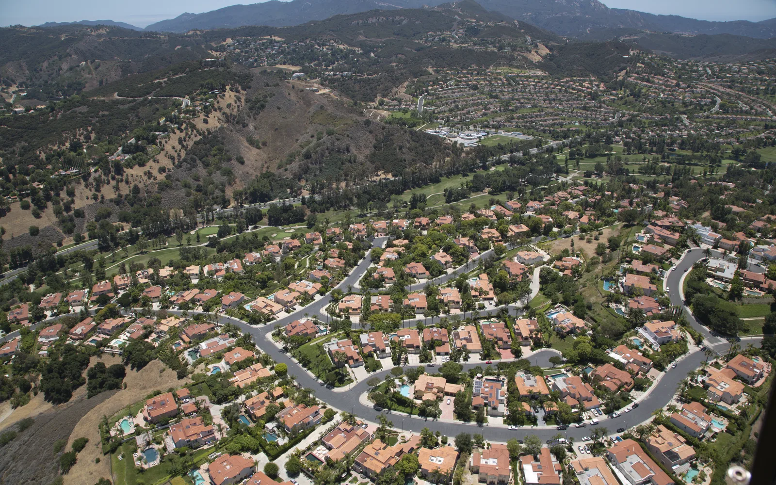 Aerial view of residential neighborhoods in Los Angeles with tree-lined streets and homes