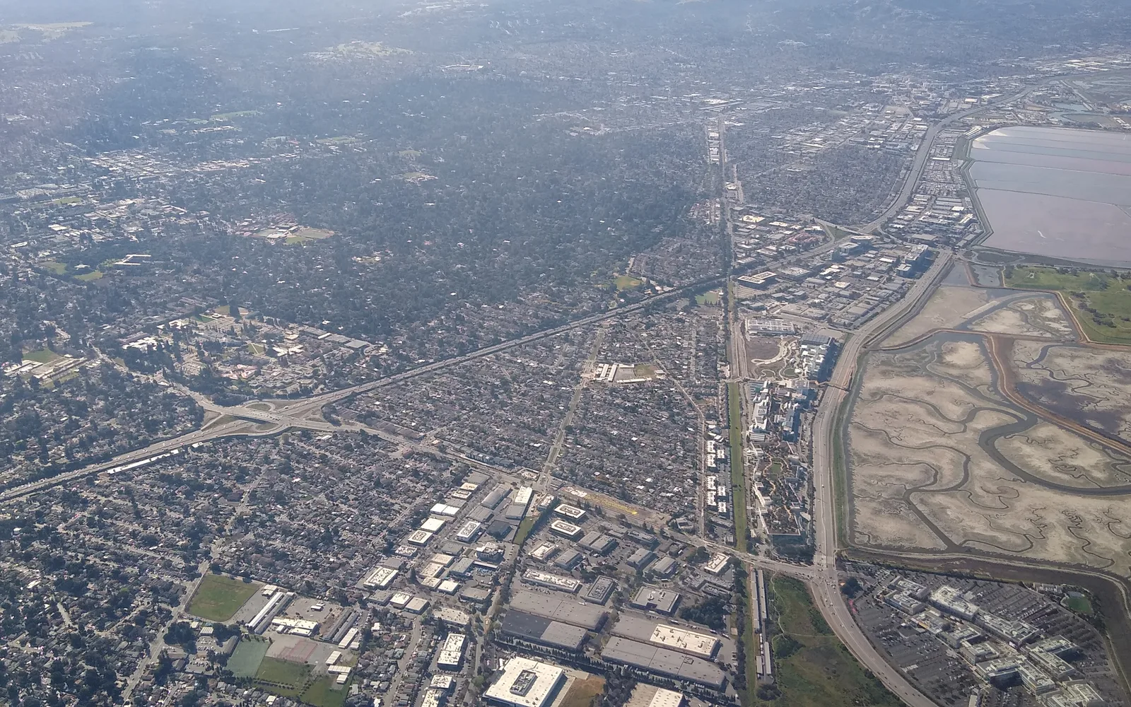 Aerial view of a residential neighborhood with tree-covered landscape
